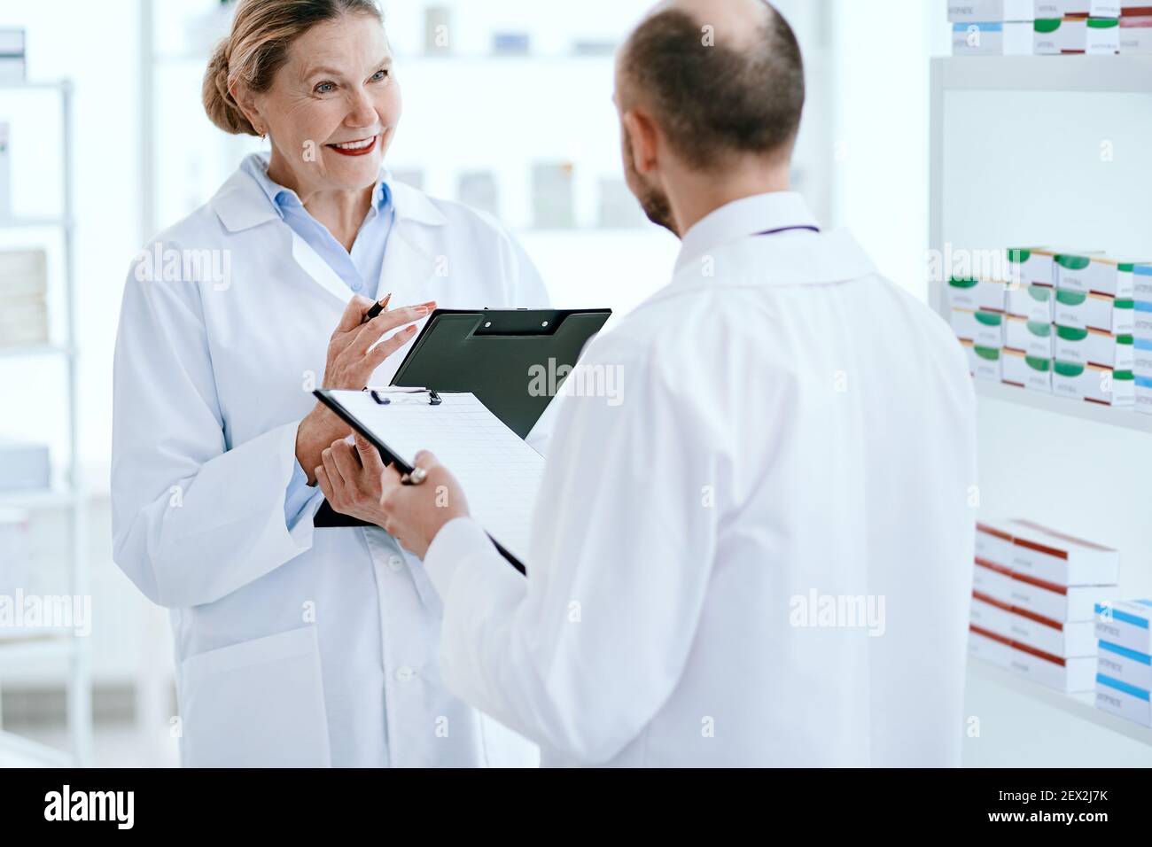 un homme et une femme pharmaciens discutent de nouveaux médicaments. Banque D'Images