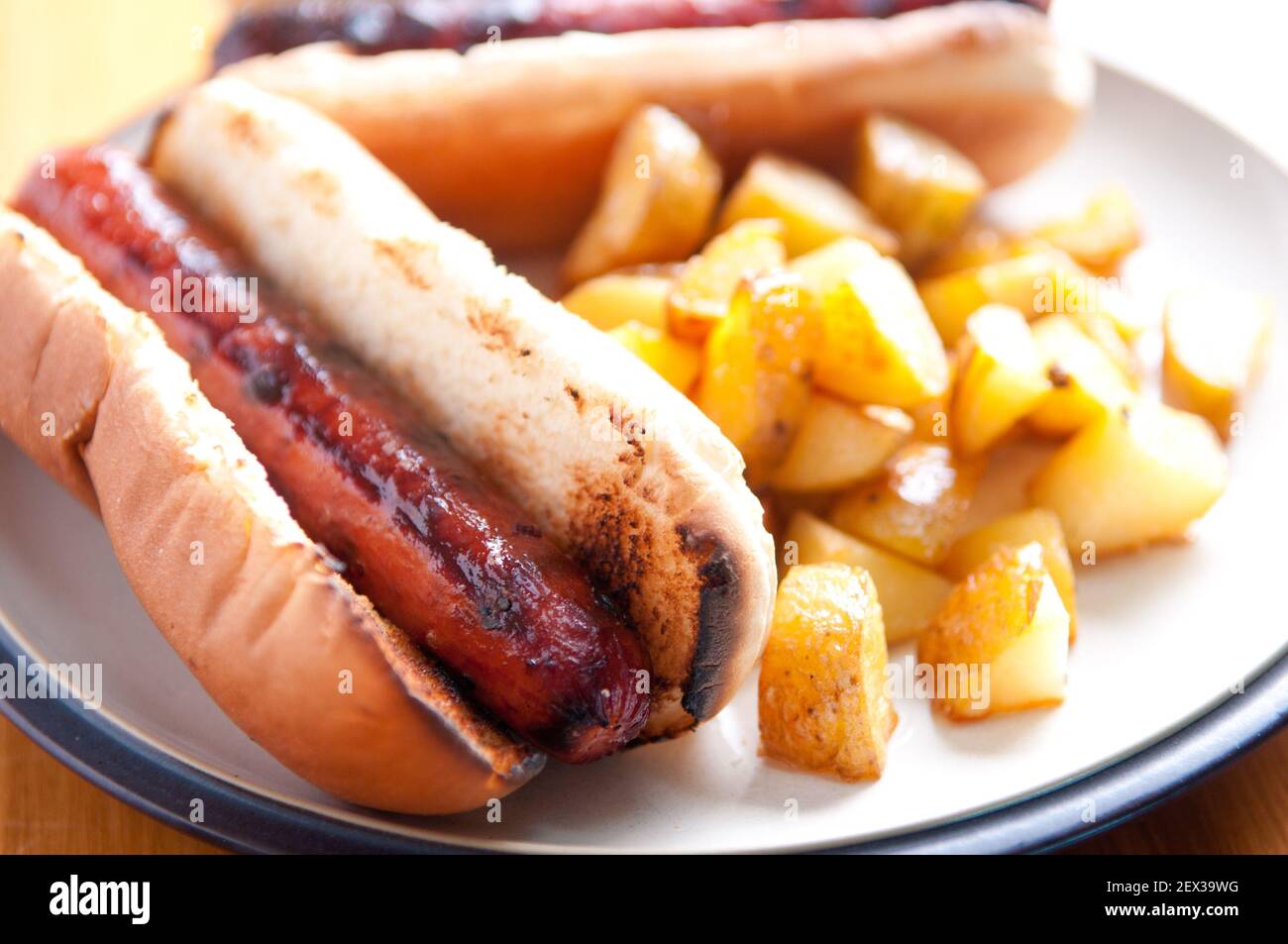 hot-dogs grillés sur pain blanc avec ketchup et pommes de terre maison. C'est un repas de déjeuner classique. Banque D'Images
