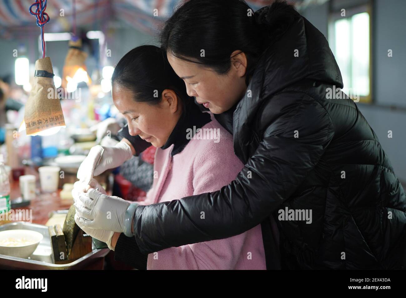 Nanchang, province chinoise du Jiangxi. 3 mars 2021. Un travailleur est formé pour insérer un noyau dans une moule afin de former une perle dans une base de culture du village de Tajiang, dans le comté de Wannian, dans la province de Jiangxi, à l'est de la Chine, le 3 mars 2021. Dans le comté de Wannian, il y a environ 3,000 femmes qui travaillent dans l'industrie de la culture des perles. Beaucoup d'entre eux vivaient autrefois dans des ménages pauvres et prenaient leurs fonctions après une formation gratuite. De nos jours, leur revenu par habitant a augmenté de 70,000 à 80,000 yuans (environ 10,822 à 12,368 dollars américains) chaque année. Credit: Zhou mi/Xinhua/Alay Live News Banque D'Images