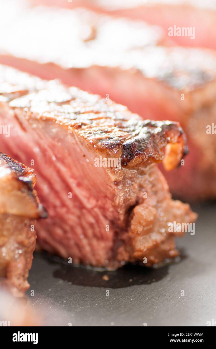 épais steak de ribeye poêlé rare sur un grill en fonte Banque D'Images