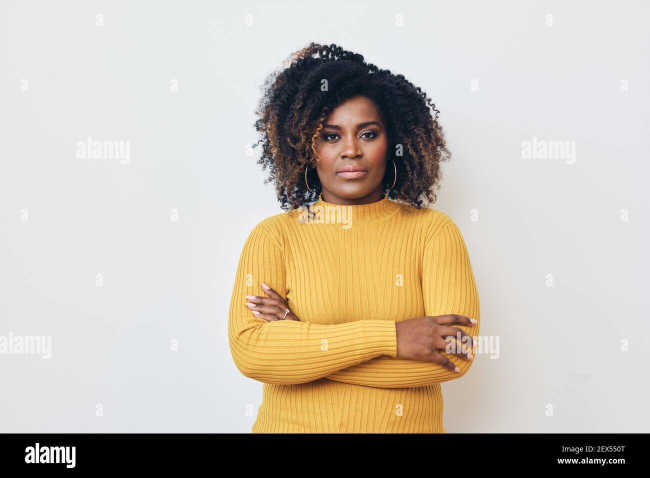 Portrait d'une femme noire sérieuse avec les bras croisés Banque D'Images