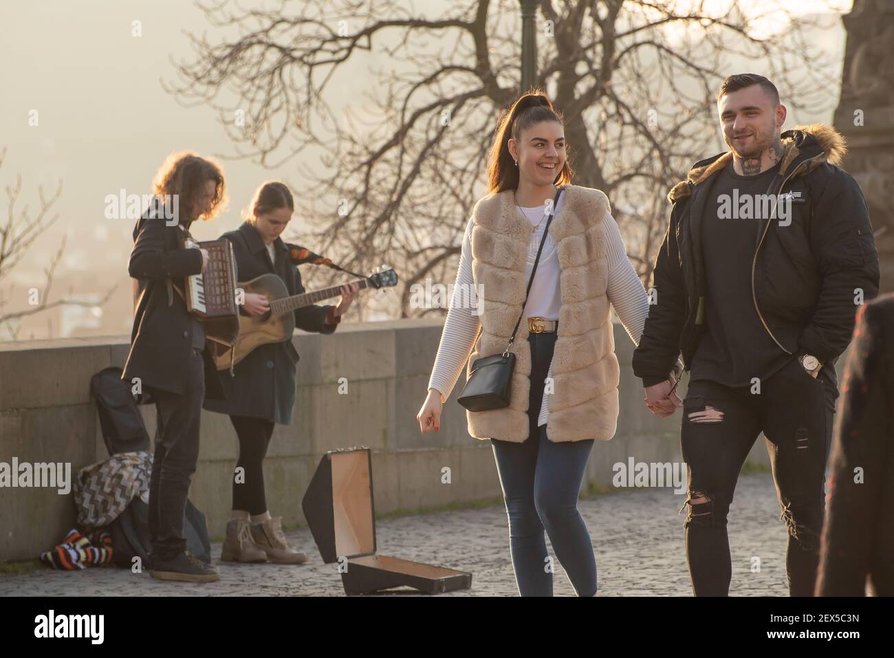 Prague, République tchèque. 03-02-2021. Le jeune couple marche, parle, souriant et s'amuse bien sur le pont Charles dans le centre-ville de Prague Banque D'Images