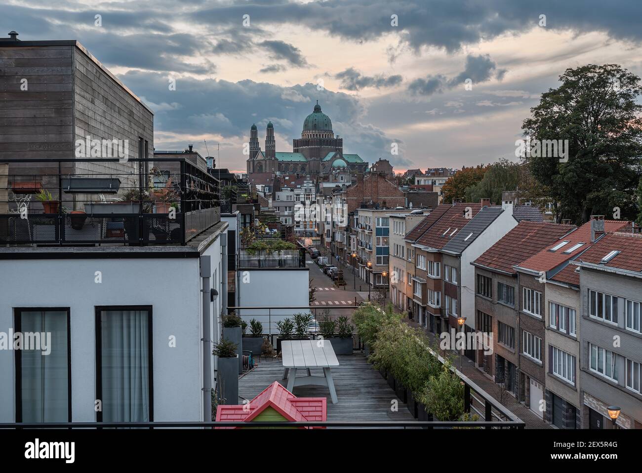 Vue sur une rue résidentielle avec appartements et le Basilique du coeur sacré pendant un coucher de soleil coloré Banque D'Images