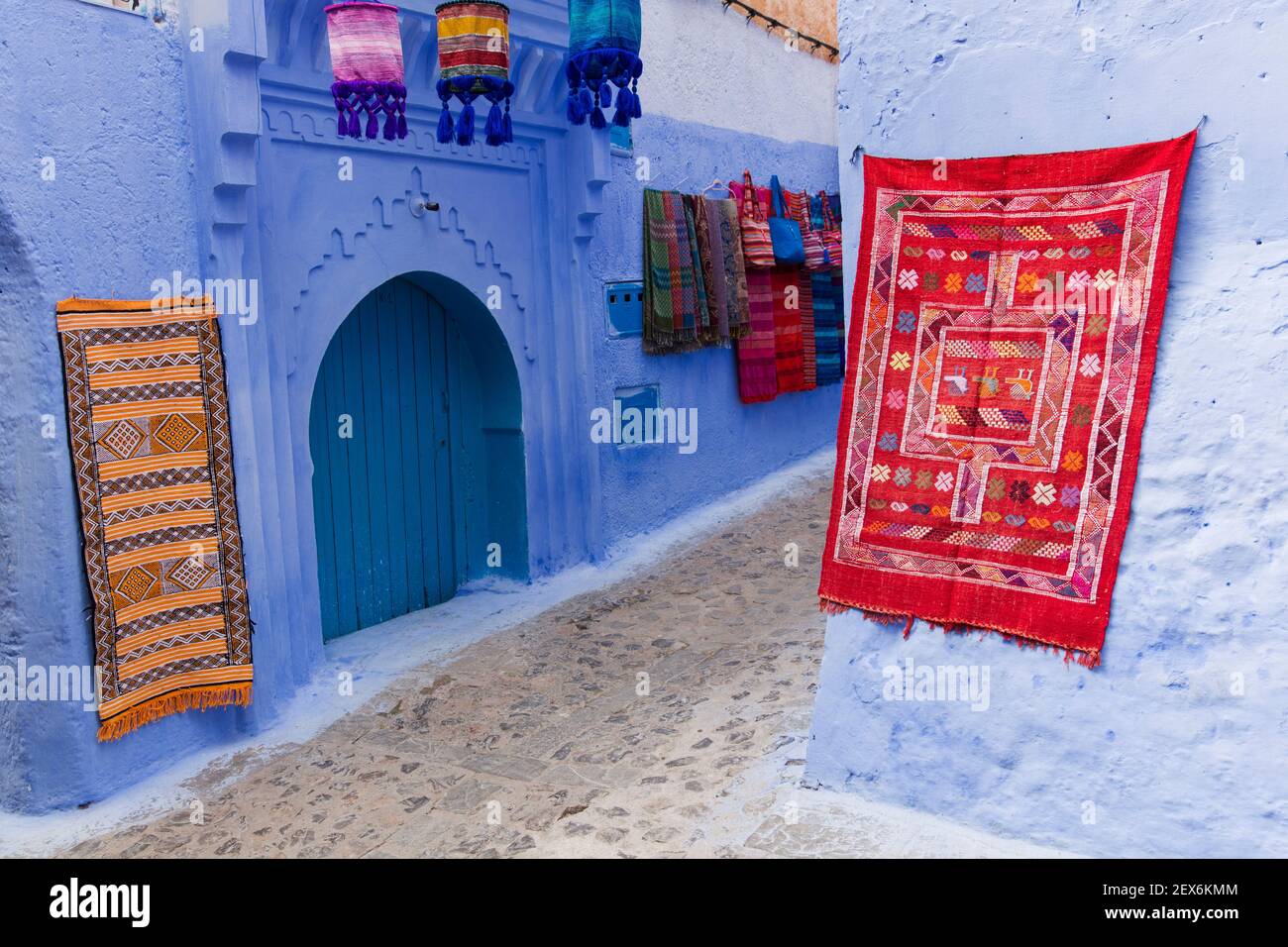 Maroc, Chefchaouen, architecture de bâtiments blancs et indigo blanchis à la chaux, tapis et tapis exposés Banque D'Images