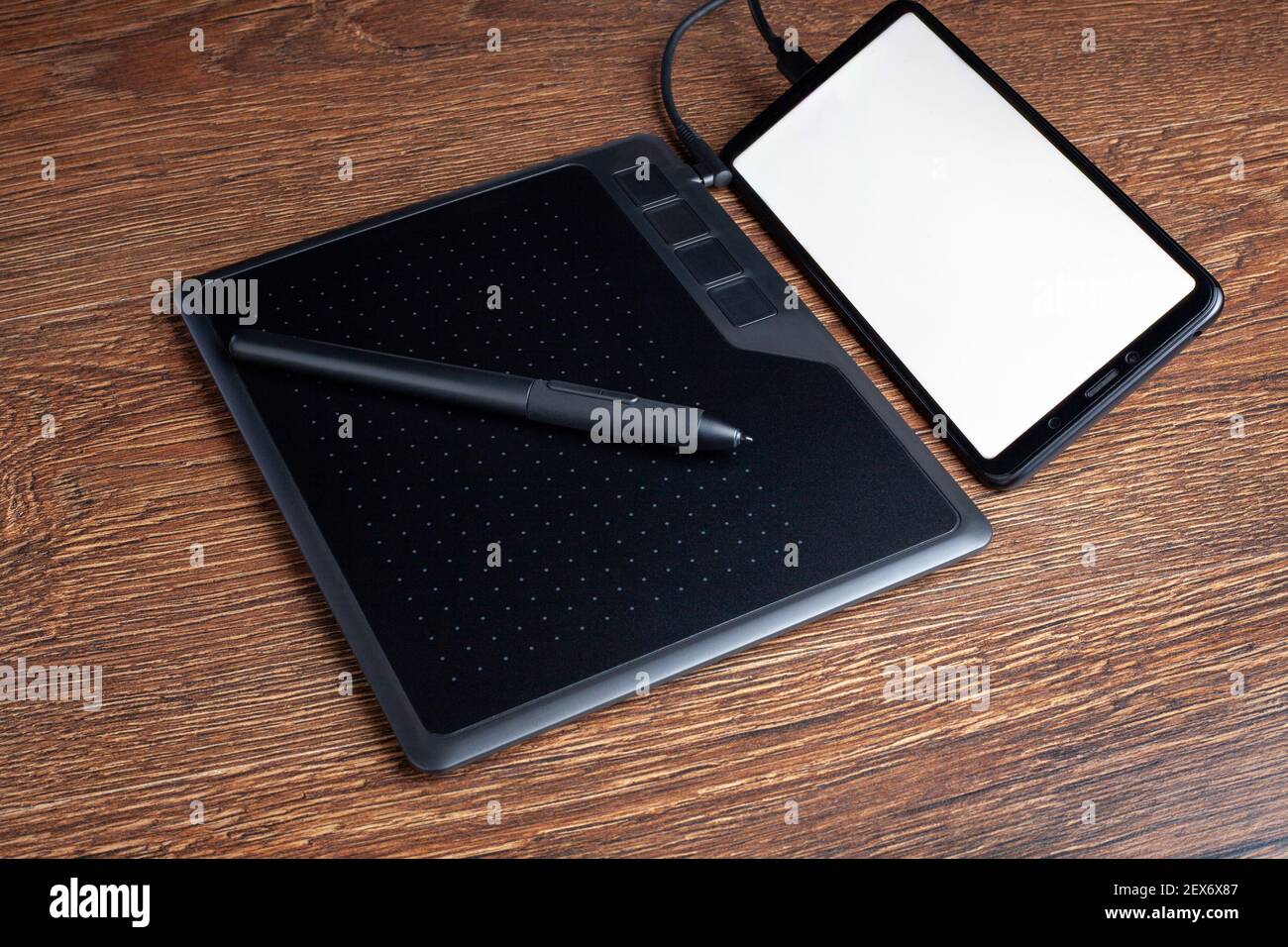 Tablette graphique tablette de retouche avec stylet numérique connecté vers  un smartphone avec un espace de copie d'écran blanc vierge Photo Stock -  Alamy