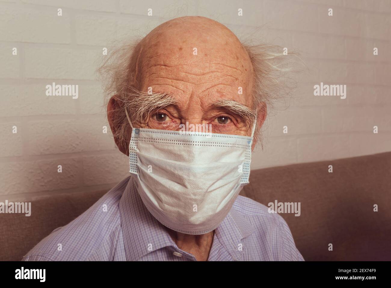 Vieil homme dans un masque médical de protection. Portrait. Grand-père caucasien dans le masque médical bleu. Concept de protection contre la grippe et les virus. Banque D'Images