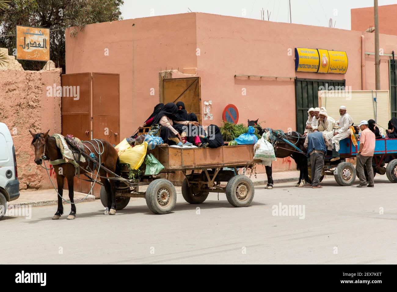 Scène de rue dans la ville de Rissani, chariot tiré par cheval occupé avec des femmes Banque D'Images