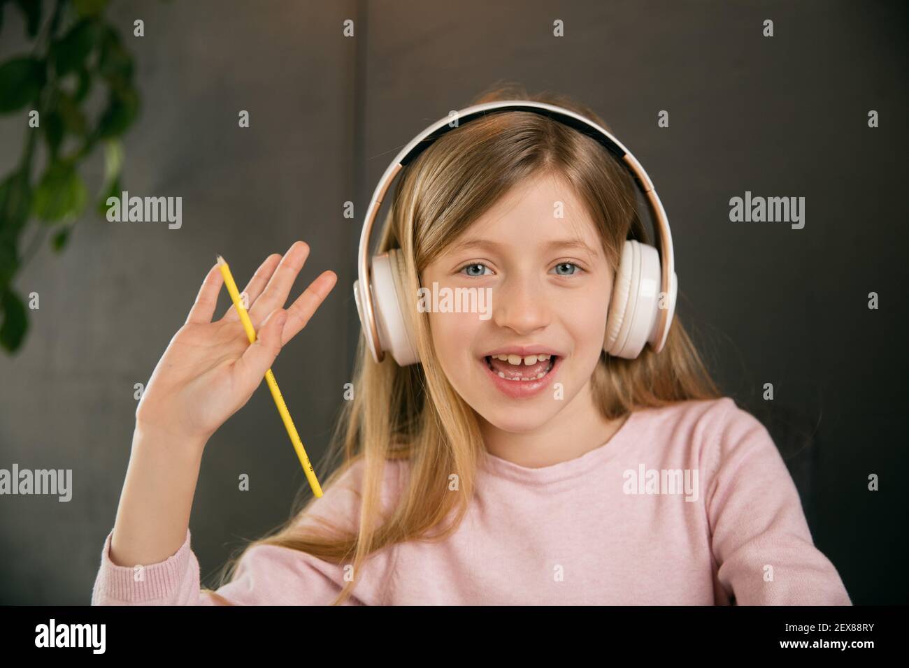 Petite fille portant des écouteurs pendant le cours d'éducation en ligne, leçon, vue de l'écran. Utilisation d'un casque. Concept d'utilisation facile et confortable, éducation, en ligne, enfance, des technologies modernes pour la remotion. Banque D'Images