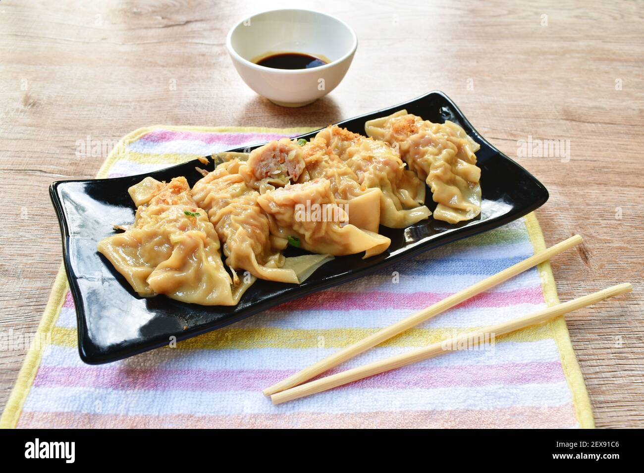 boulettes bouillies ou gyoza farcies écrasées de porc et de crevettes avec garniture de légumes frit, hacher l'ail sur une assiette en trempant le soja doux sauce Banque D'Images