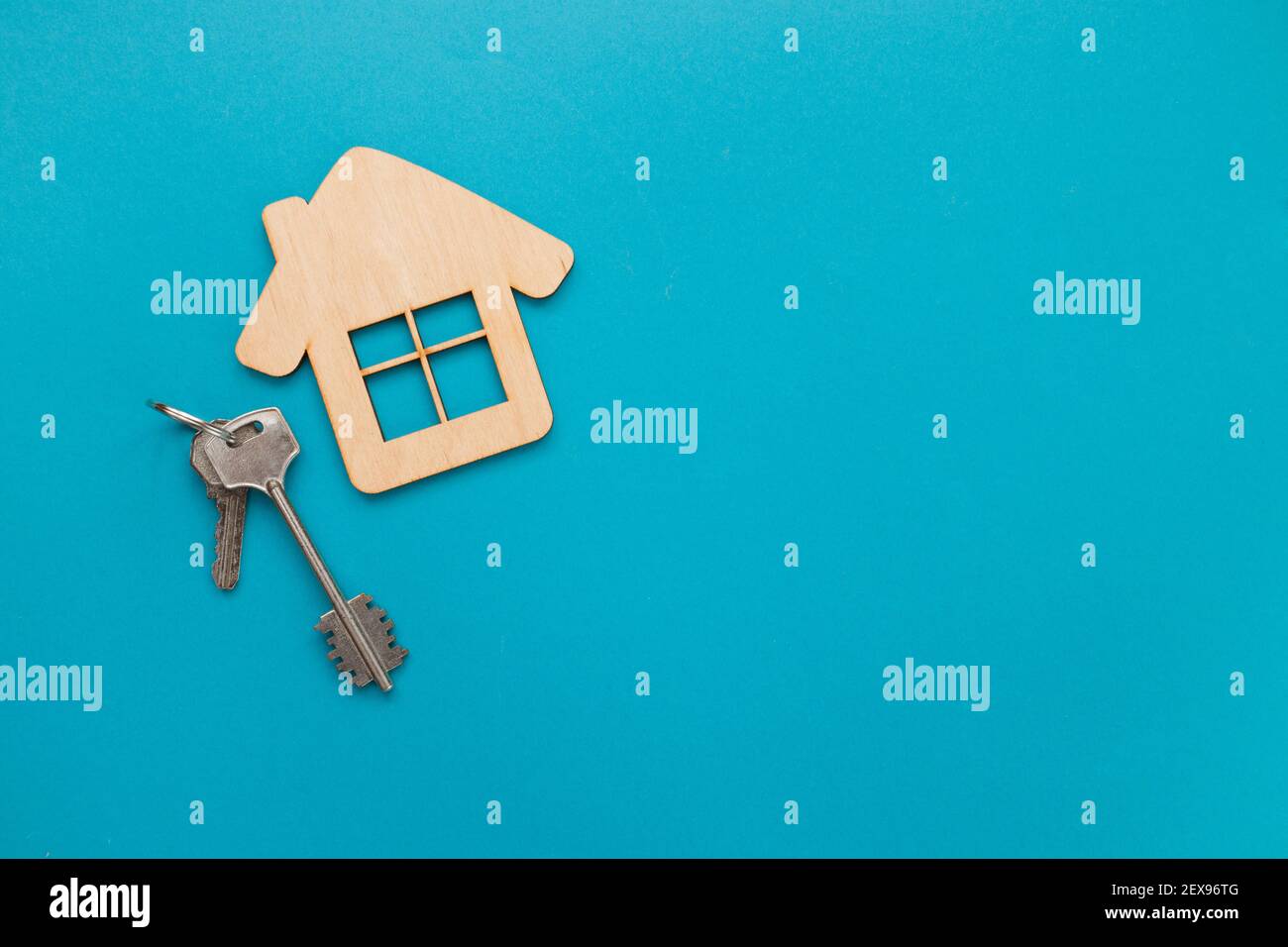 Gros plan de la maison modèle en bois et clés sur fond bleu. Assurance de biens immobiliers acheter maison de rêve vente loyer concept. Vue de dessus, plan d'appartement Banque D'Images