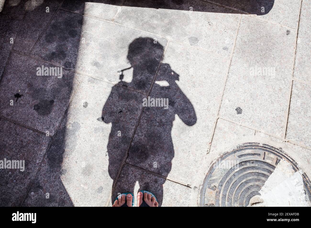 Un enfant prenant une image de son ombre sur le sol Banque D'Images