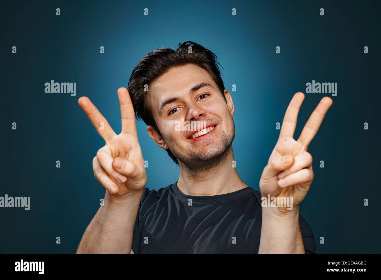 Jeune homme brunette signe de paix positif portrait Banque D'Images