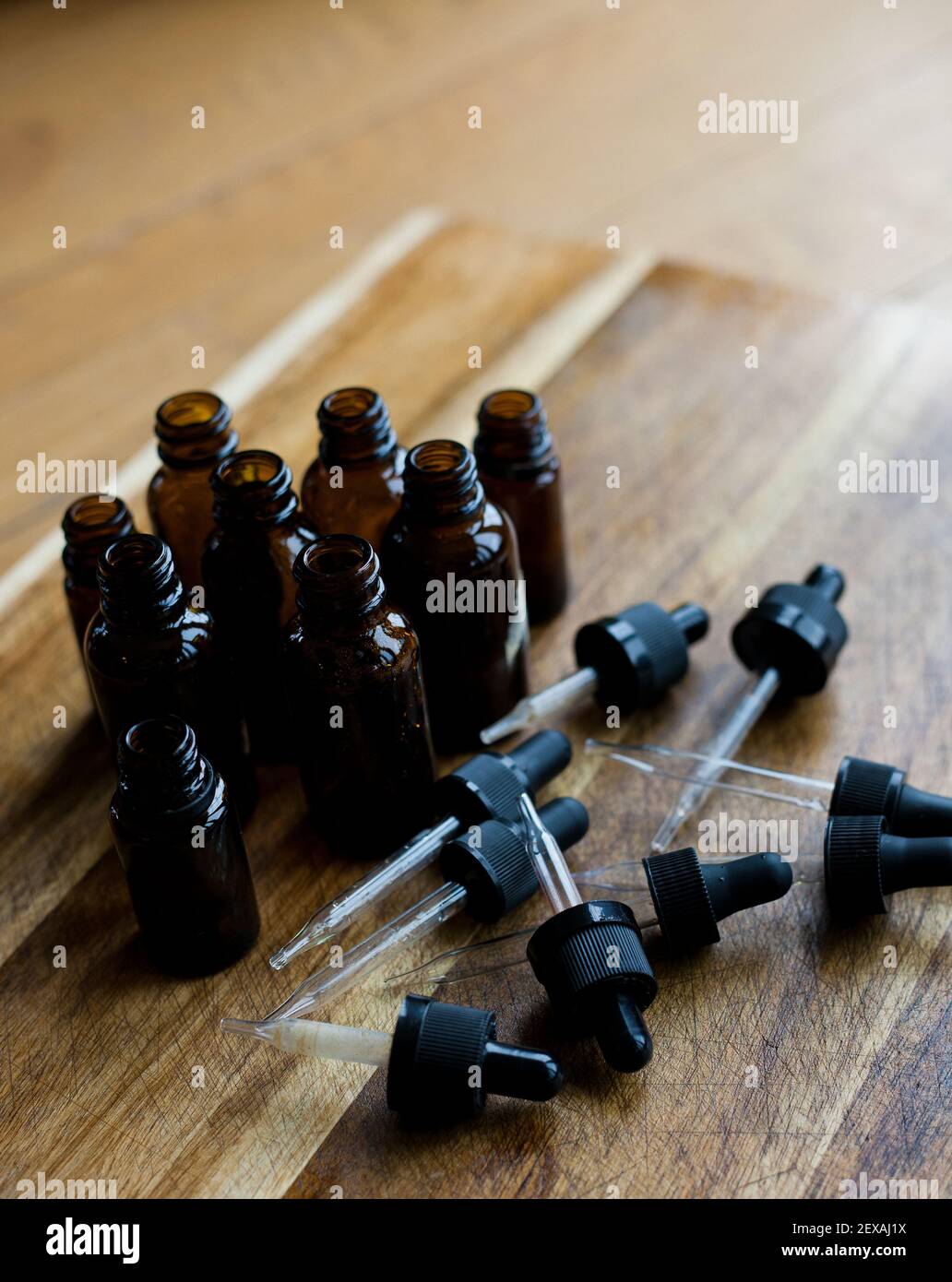 Une collection de flacons compte-gouttes ambrés sur fond en bois Banque D'Images