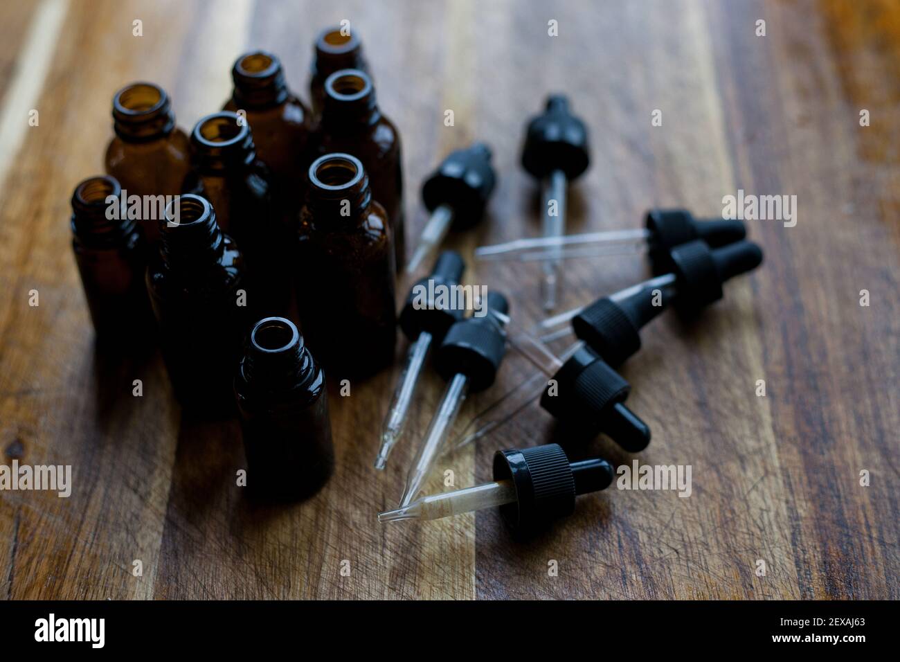 Une collection de flacons compte-gouttes ambrés sur fond en bois Banque D'Images