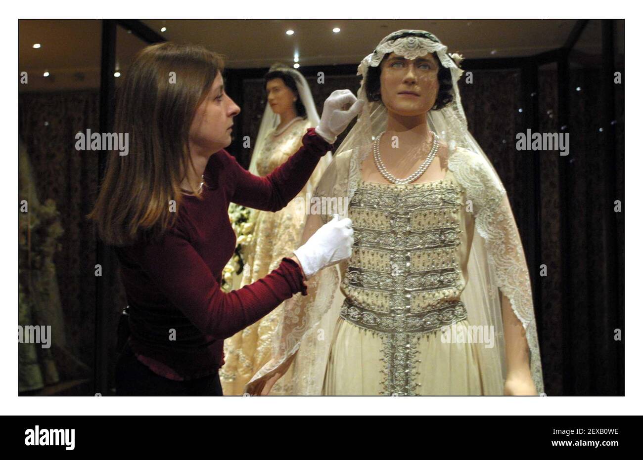 Cinq robes de mariage royales sont exposées ensemble pour la première fois dans les appartements d'état du Palais de Kensington, l'exposition, Acentury of Queens Wedding robes 1840-1947 s'ouvrira au public le 1er mai pour commémorer le Jubilé d'or du Queens. Jenny Lister conservateur adjoint au Palais de Kensington fait quelques ajustements à la robe de la reine mère en arrière-plan est la robe de sa Majesté la reine Elizabeth ll. pic David Sandison 30/4/2002 Banque D'Images
