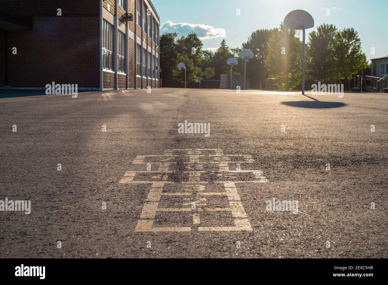 Bâtiment de l'école et cour d'école le soir. Jeu de hopscotch sur l'asphalte dans le terrain de jeu de cour d'école. Banque D'Images