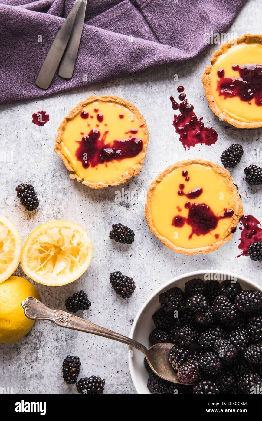 Plat de nourriture de mini-tartes de Custard de citron avec confiture de mûres Banque D'Images