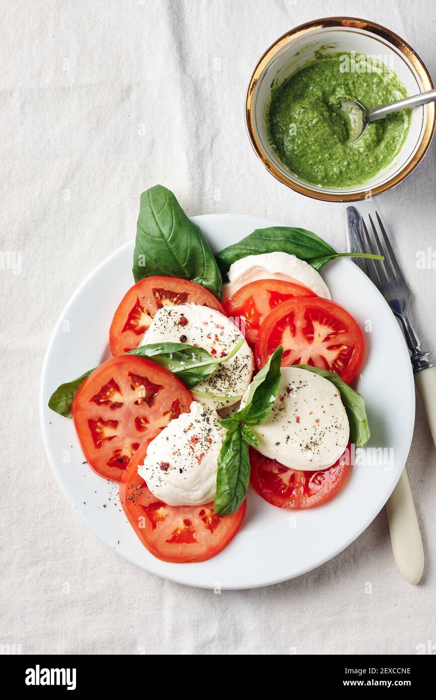 Salade Caprese. Tomates, fromage mozzarella, feuilles de basilic et sauce pesto. Banque D'Images