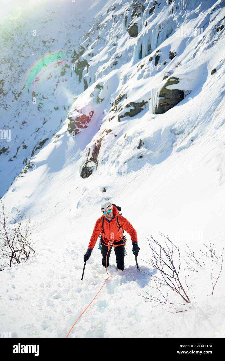 Un guide d'escalade sur glace de sexe masculin mène une ascension sur glace à New Hampshire Banque D'Images