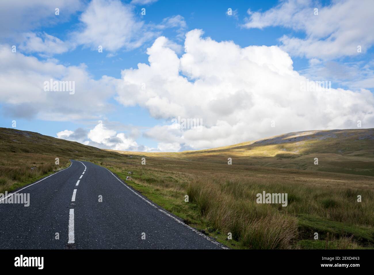 Route vide non clôturée traversant des collines dans le parc national de Brecon Beacons, Carmarthenshire, pays de Galles du Sud, Royaume-Uni Banque D'Images