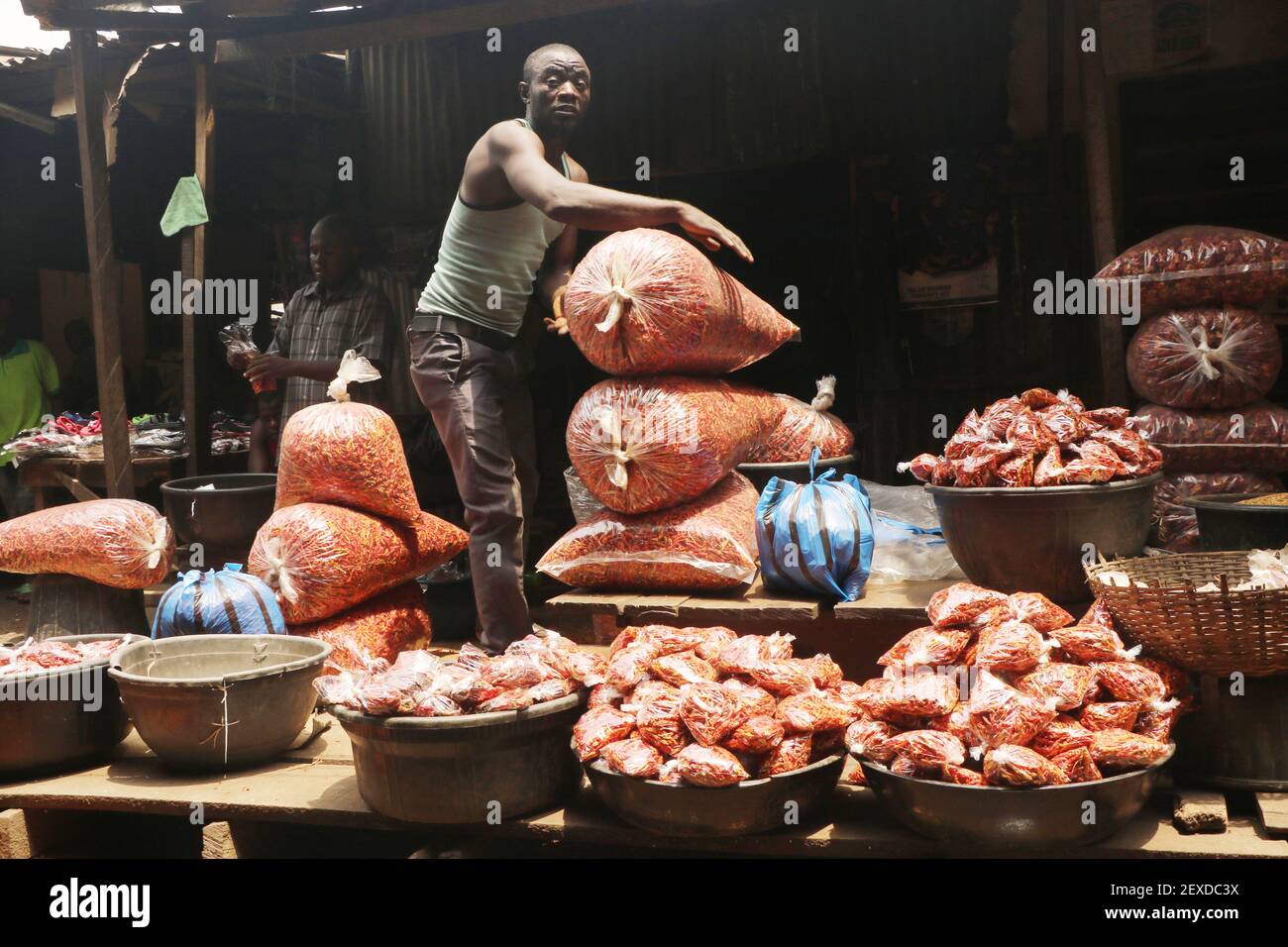 Un négociant organise la vente de sacs de poivre sec, alors qu'il attend des clients sur le marché alimentaire de Lagos, dans le district Mile-12 de Lagos, au Nigeria. Banque D'Images