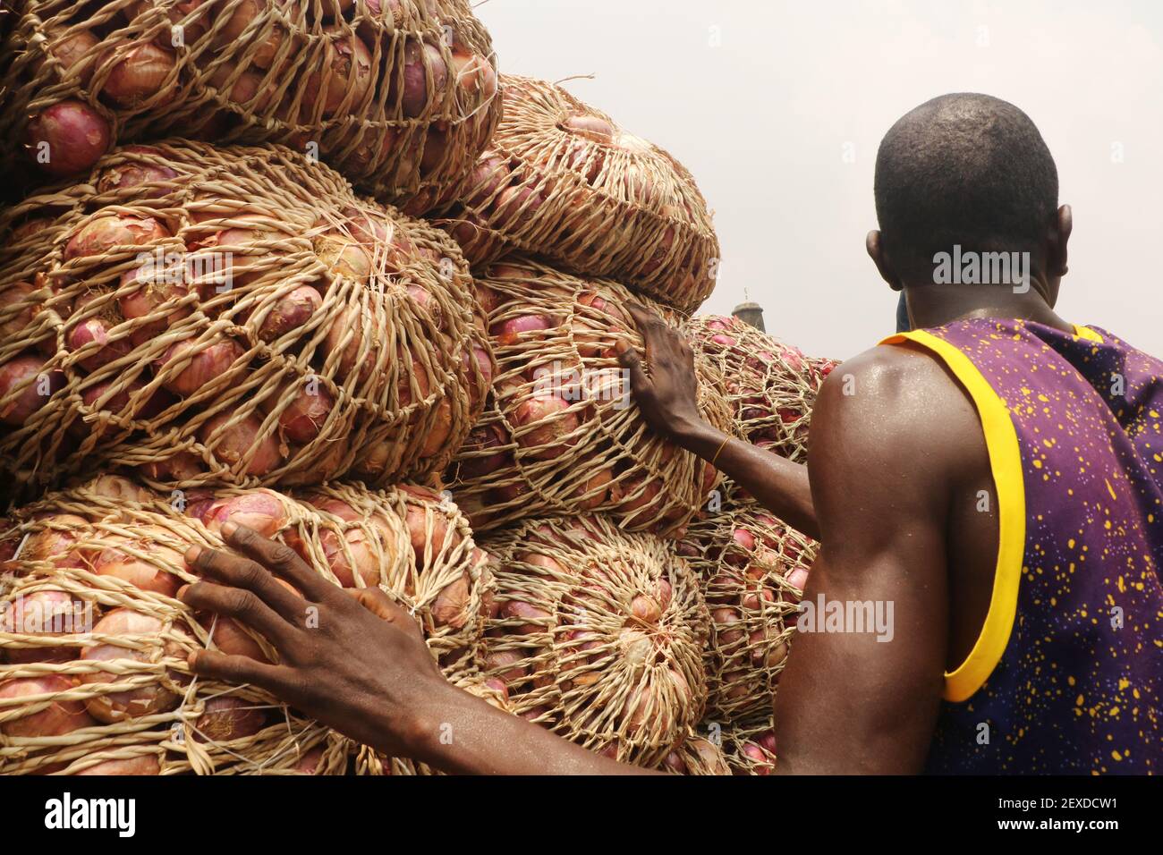 Un négociant organise la vente de sacs d'oignons, alors qu'il attend des clients sur le marché alimentaire de Lagos, dans le district Mile-12 de Lagos, au Nigeria. Banque D'Images