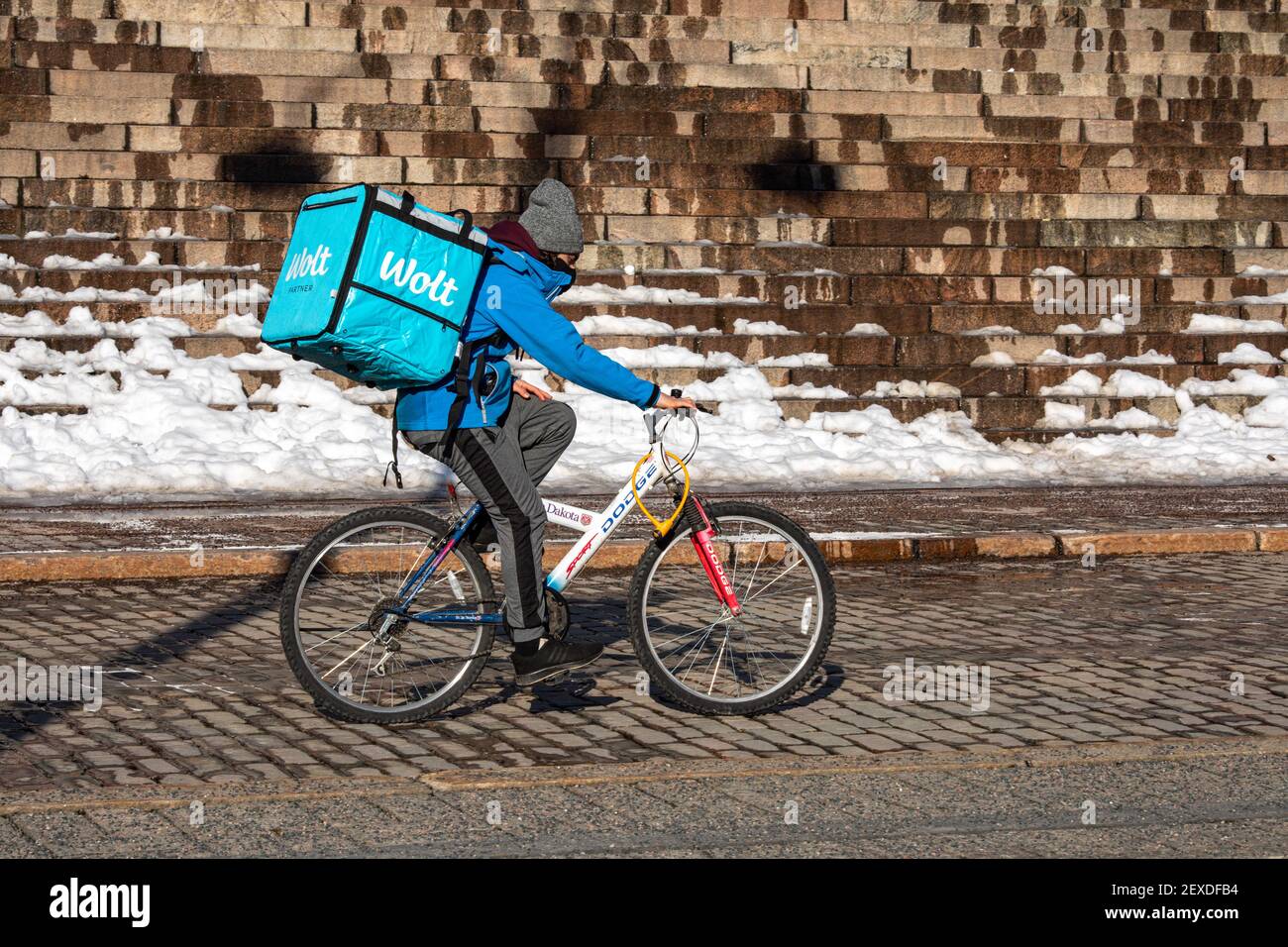Wolt livraison de nourriture avec sac à dos thermique en vélo le long de la cathédrale d'Helsinki marche un jour d'hiver ensoleillé à Helsinki, en Finlande Banque D'Images