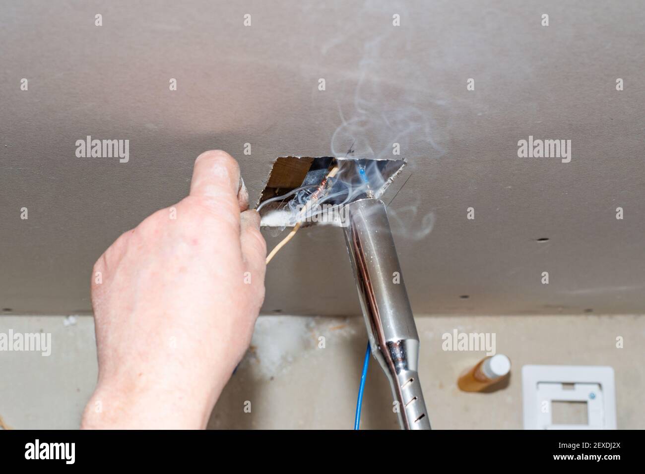 Un électricien soud des fils électriques torsadés dans une prise. Installation des communications et isolation des fils. Banque D'Images