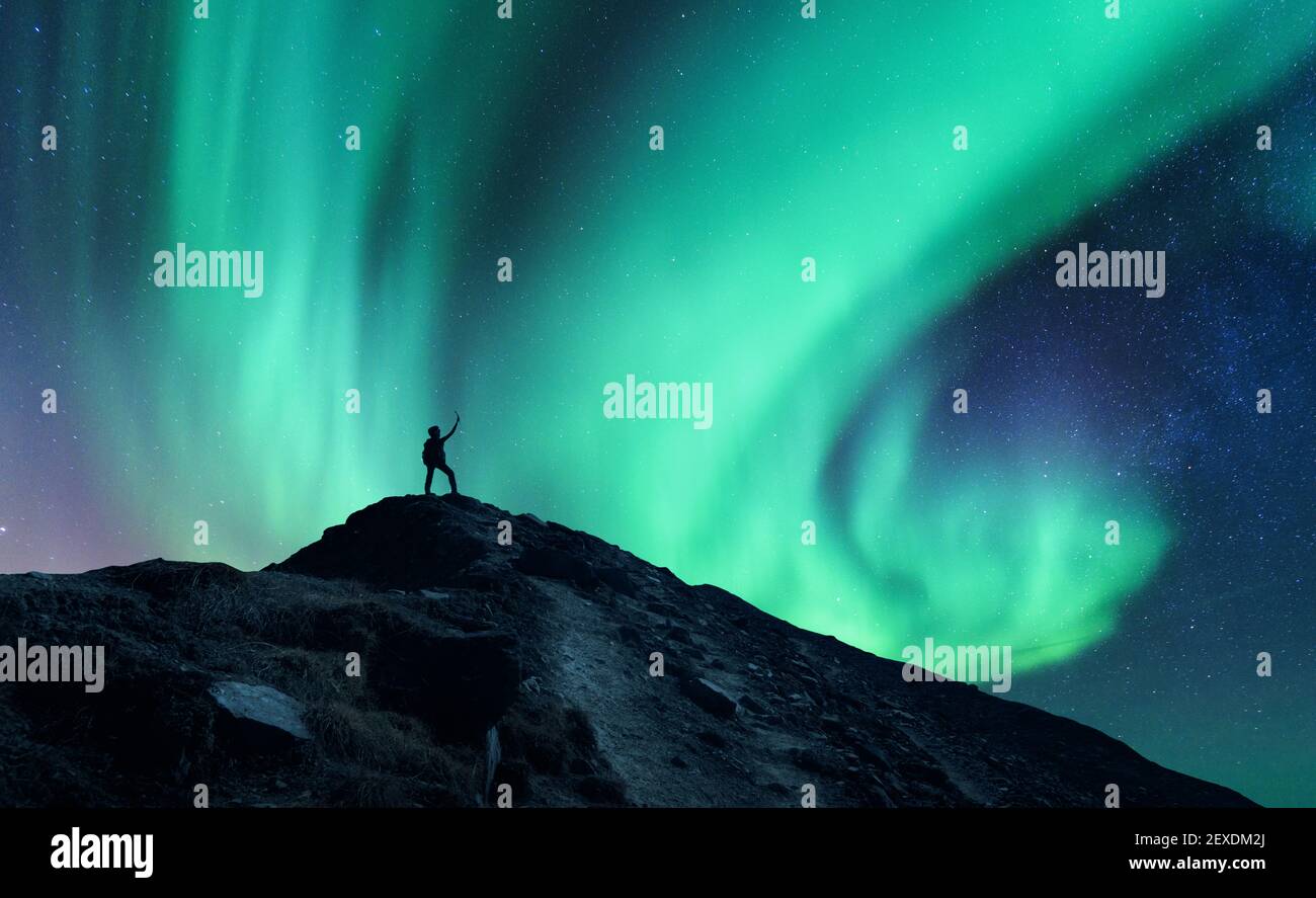 Lumières nordiques et silhouette d'homme debout avec surélevés ar Banque D'Images