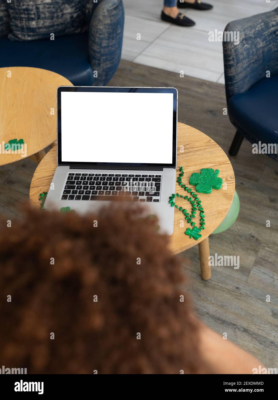 Femme de course mixte célébrant la journée de St patrick sur PC portable appel avec espace de copie à l'écran Banque D'Images