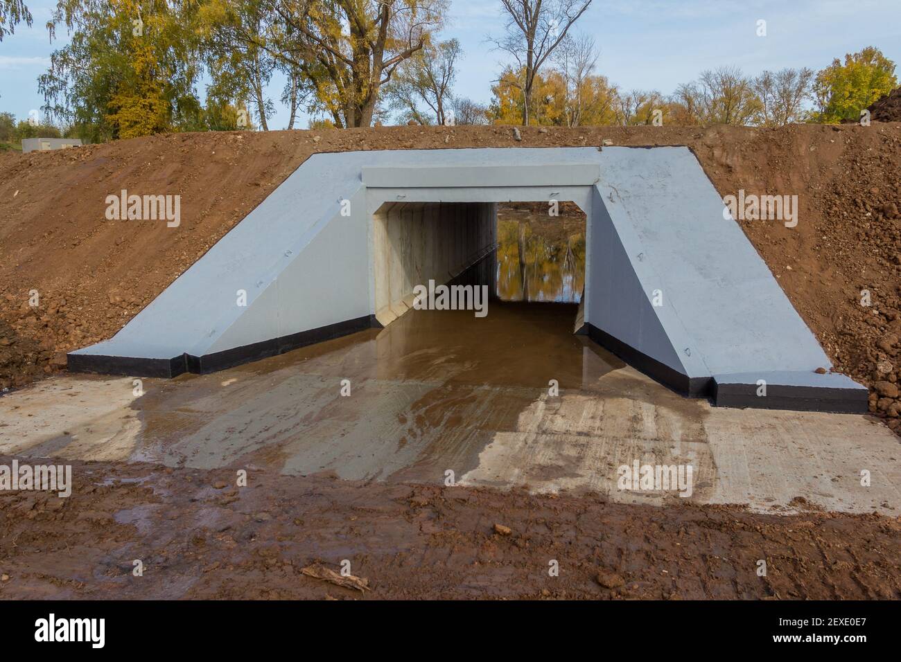 Petit pont en béton de l'autre côté de la route. Un pont de l'autre côté d'une route pour une petite rivière. Structure en béton sur une route Banque D'Images
