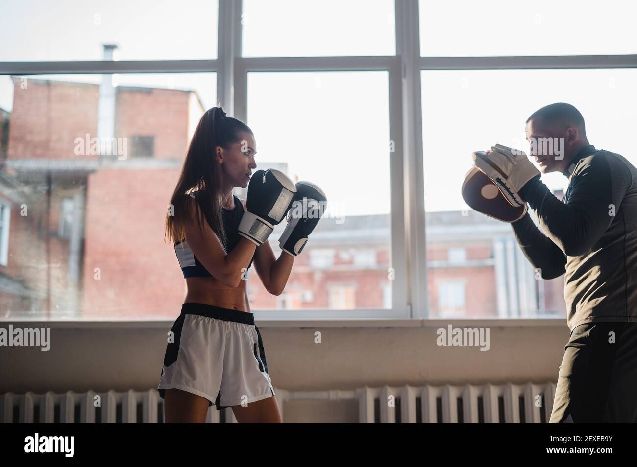 Femme entrainement boxe avec entraîneur personnel. Instructeur enseignant à  la femme boxer s'entraîner ensemble à la lutte Photo Stock - Alamy