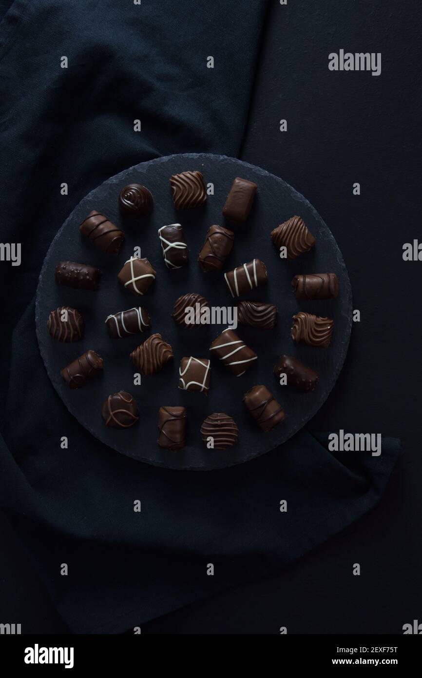Assortiment de bonbons au chocolat sur plateau noir Banque D'Images