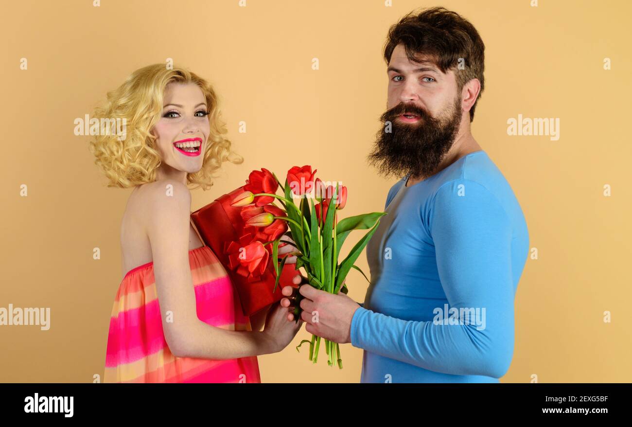 Le petit ami donne le bouquet de fleurs à la petite amie. Amour, relation, rencontres, anniversaire. L'homme félicite la femme pour son anniversaire. Banque D'Images