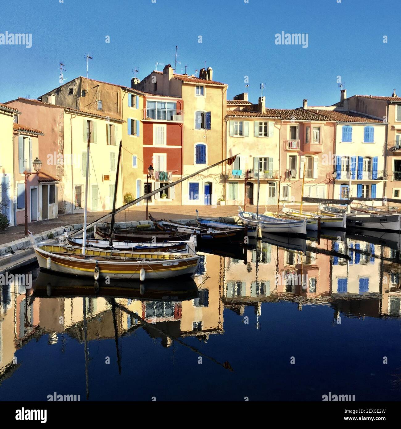 Photo idyllique d'un petit port de Martigues près de Marseille appelé miroir d'oiseau avec des maisons colorées et de petits bateaux reflétant activé Banque D'Images