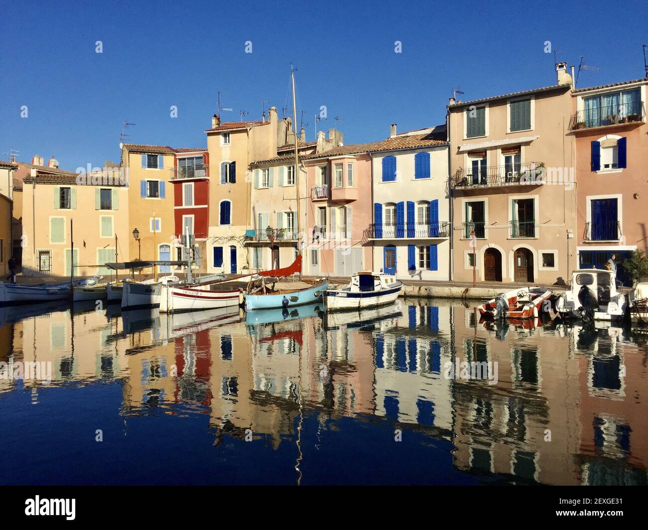 Photo idyllique d'un petit port de Martigues près de Marseille appelé miroir d'oiseau avec des maisons colorées et de petits bateaux reflétant activé Banque D'Images