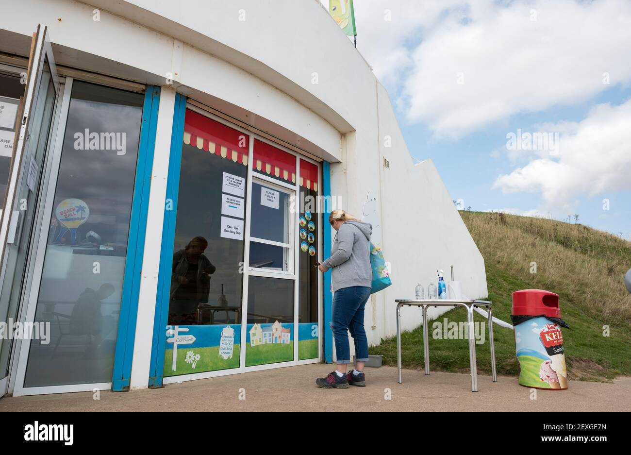 Femme blonde attendant devant un café Banque D'Images