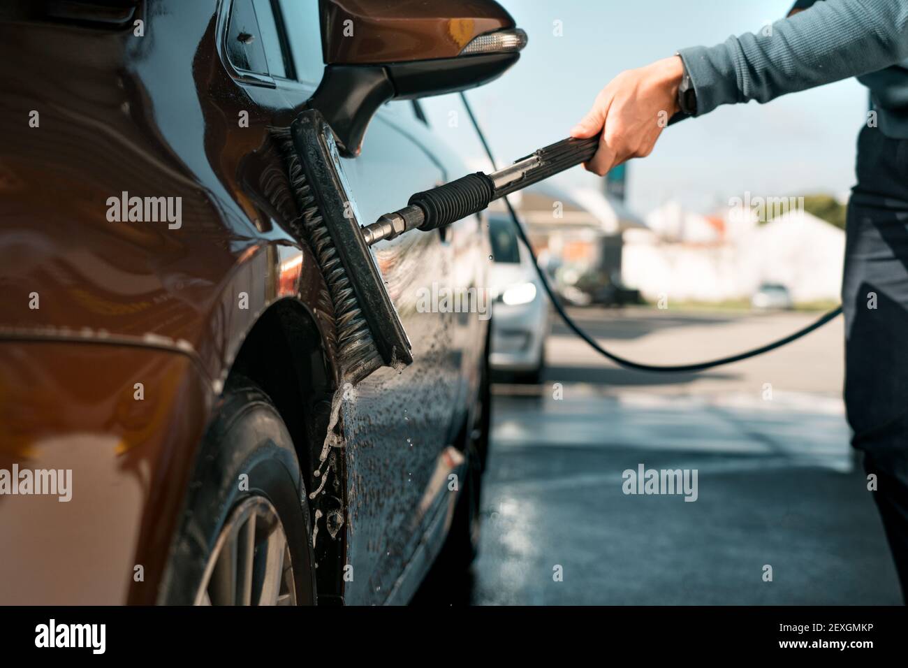 Lavage de voiture avec une brosse dans le lavage de voiture libre-service. Nettoyage de la voiture à l'extérieur au poste de lavage de voiture. Lavage intelligent. Banque D'Images