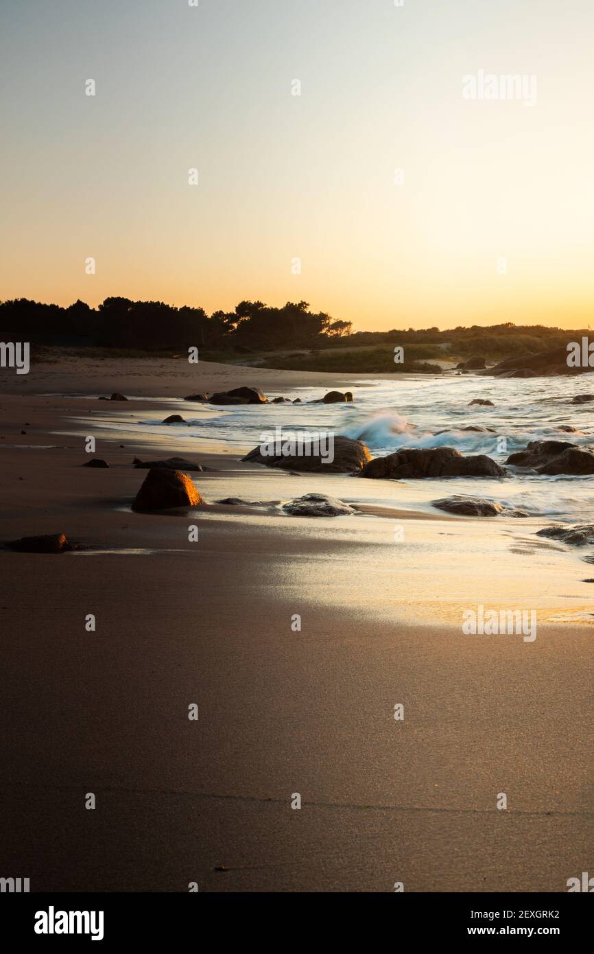 Coucher de soleil sur une plage avec formations rocheuses sur le galicien côte Banque D'Images