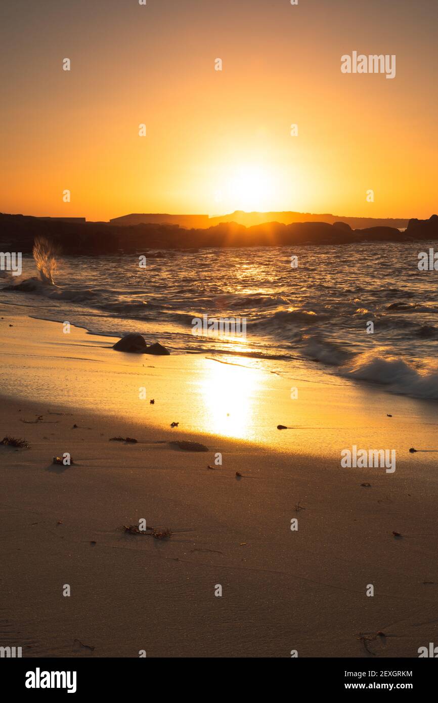 Coucher de soleil sur une plage avec formations rocheuses Banque D'Images