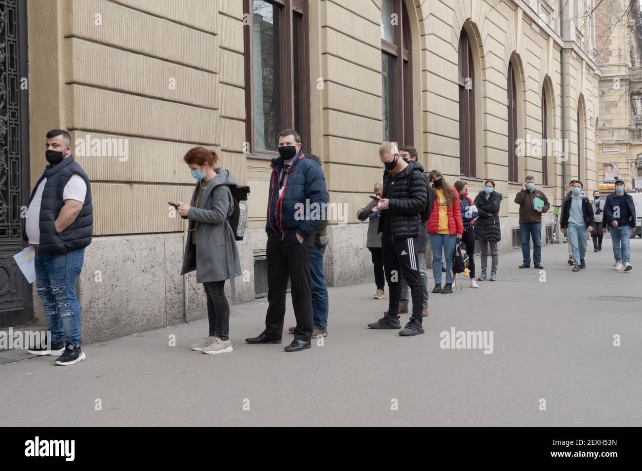 Budapest, Hongrie. 4 mars 2021. Les personnes portant un masque facial font la queue devant un bureau de poste à Budapest, en Hongrie, le 4 mars 2021. Le gouvernement hongrois a présenté jeudi un ensemble de règles plus strictes pour lutter contre la troisième vague de pandémie, les nouvelles infections quotidiennes ayant dépassé les 6,000 000, un niveau jamais vu depuis novembre dernier. Credit: Attila Volgyi/Xinhua/Alay Live News Banque D'Images
