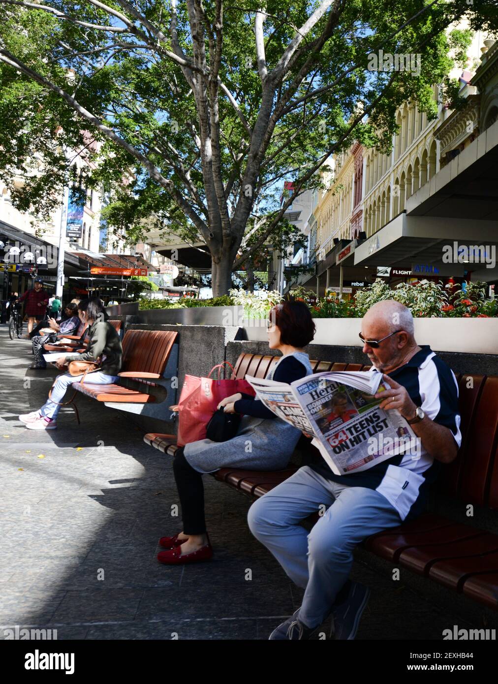 Un australien lisant le journal sur Albert Street à Brisbane, en Australie. Banque D'Images