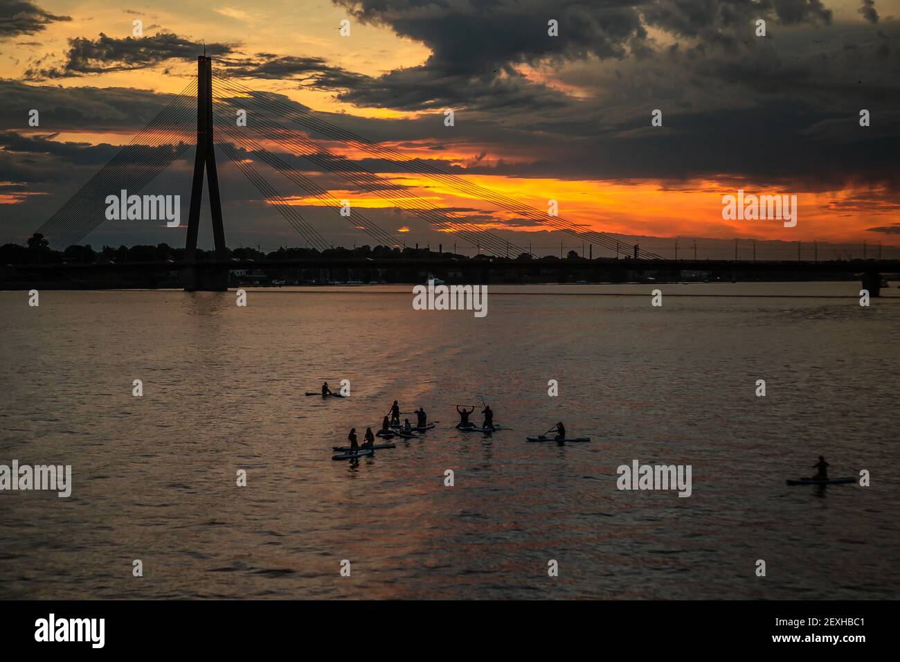 Un groupe de personnes appréciant pagayer avec stand-up paddleboards avec Fond du pont Vansu pendant le coucher du soleil Banque D'Images