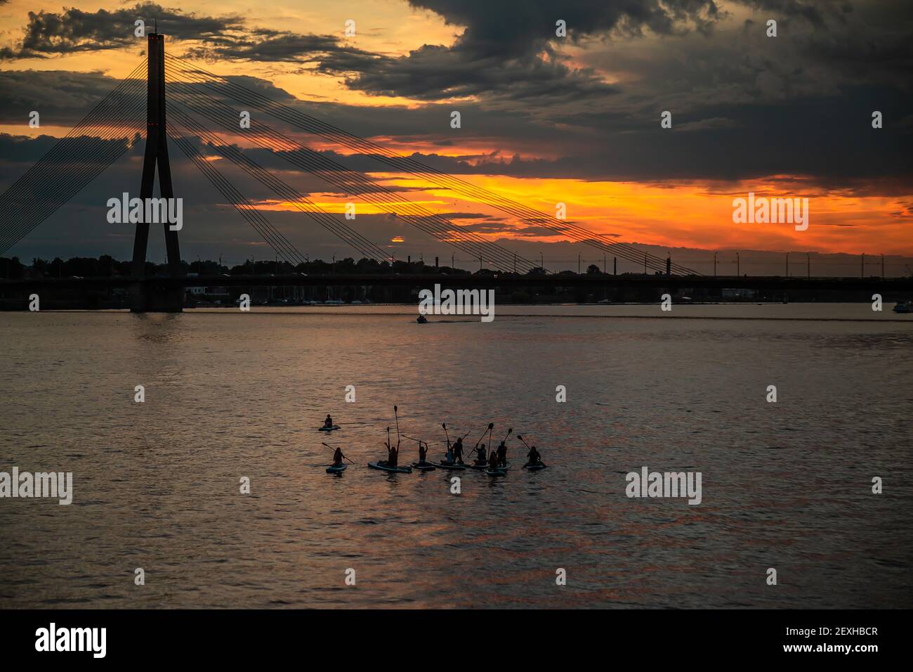 Un groupe de personnes appréciant pagayer avec stand-up paddleboards avec Fond du pont Vansu pendant le coucher du soleil Banque D'Images