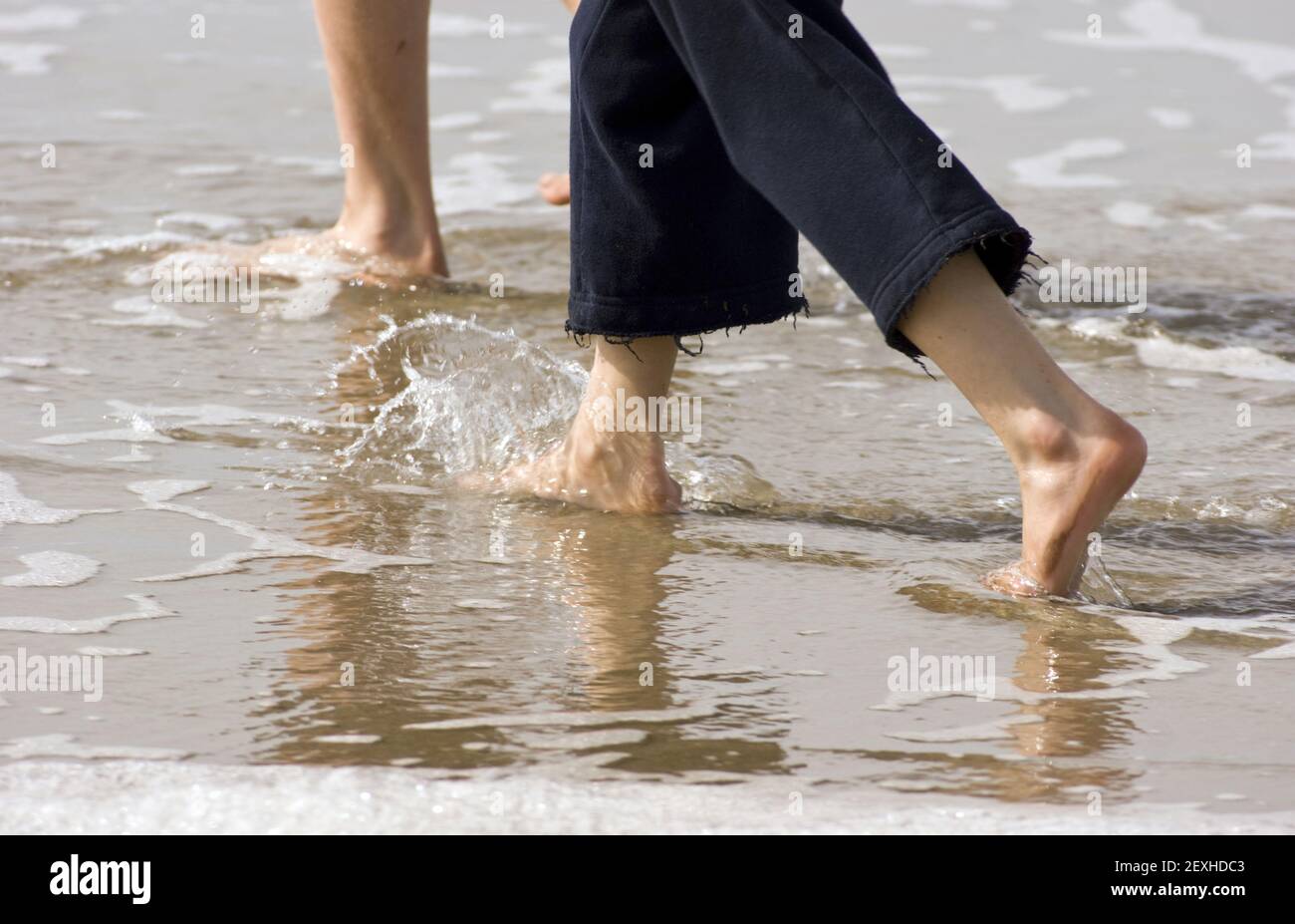 Les jeunes adolescents du bas des jambes marche sur la plage Banque D'Images