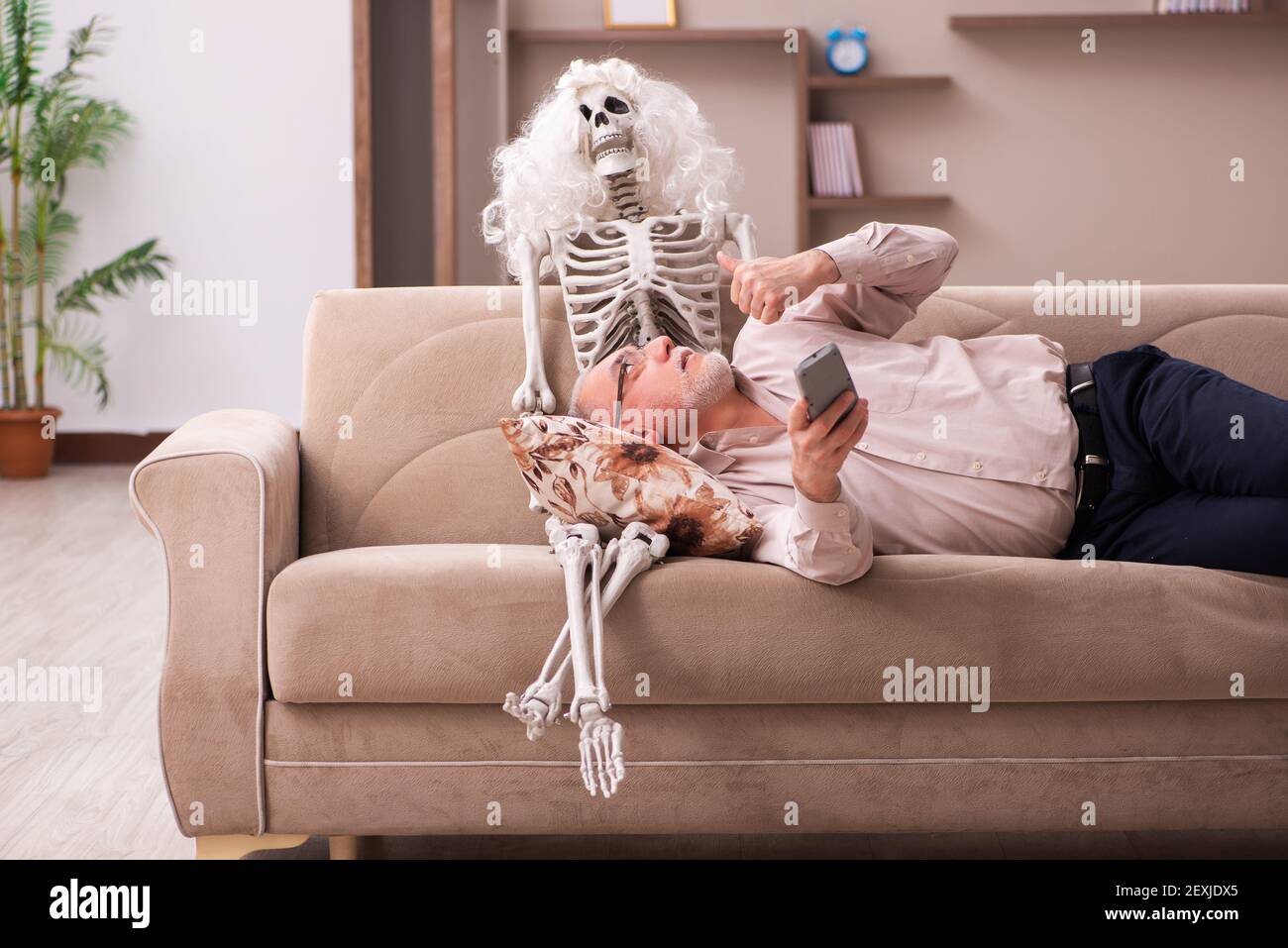 Vieil homme assis sur le canapé avec le squelette féminin dans le concept  d'amour unying Photo Stock - Alamy