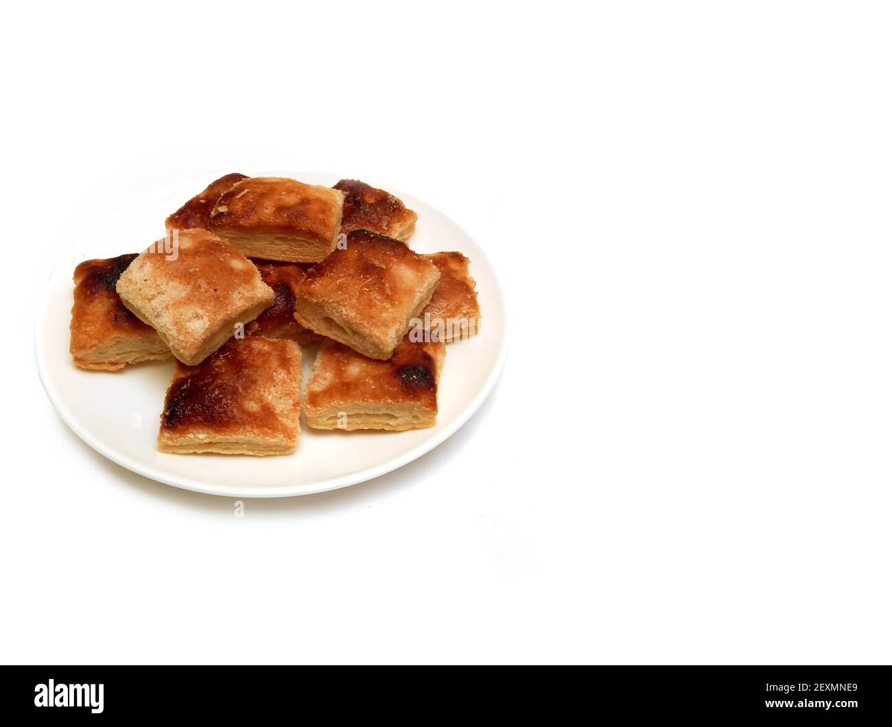 Photo en grand angle de biscuits de pâte feuilletée avec du sucre fondu sur fond blanc. Boulangerie classique Argentine. CopySpace Banque D'Images