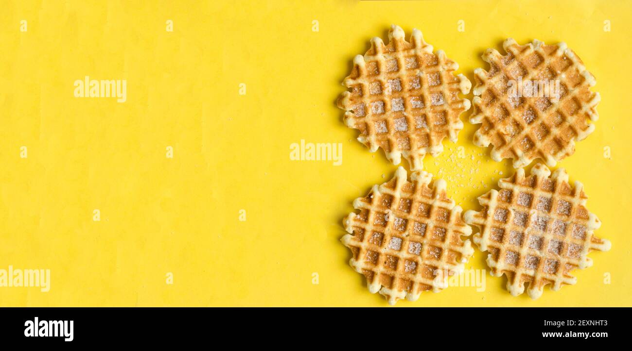 Vue de dessus, quatre gaufres belges sucrées sur fond jaune, copyspace.Sweet dessert. Banque D'Images