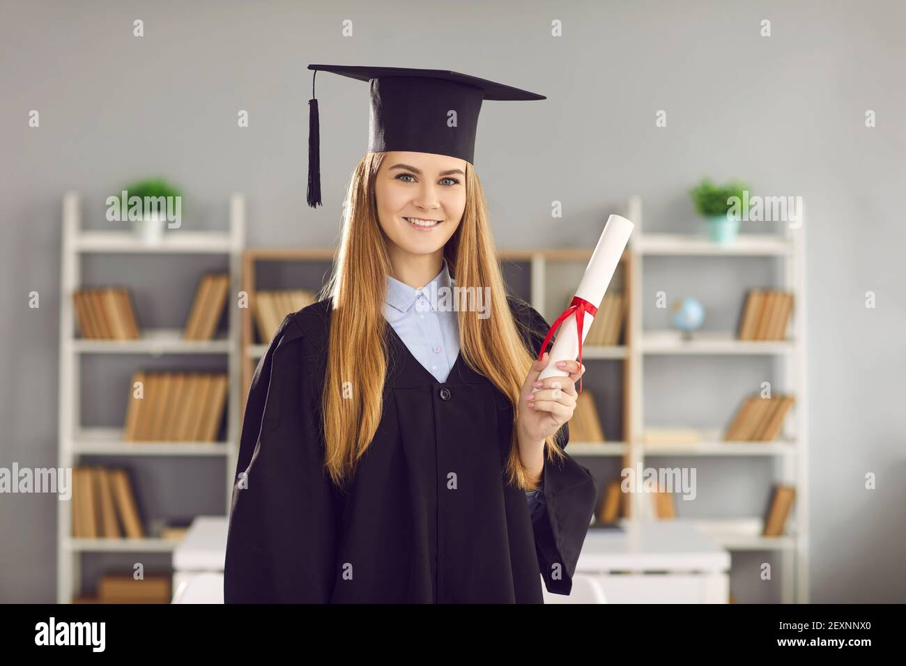 Portrait du diplôme d'études supérieures ou universitaires heureux et sourire à l'appareil photo Banque D'Images