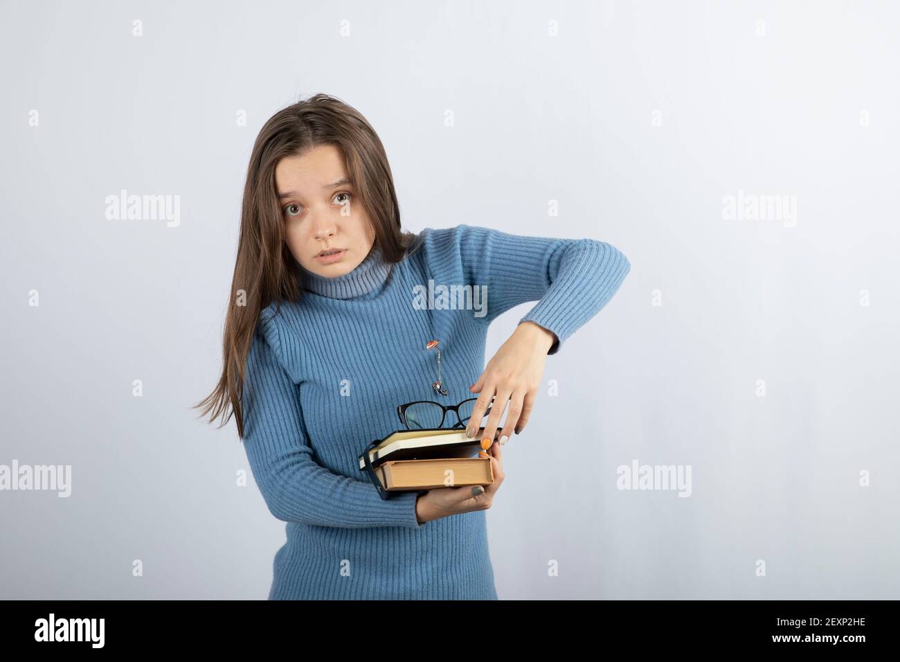 Photo d'une jeune fille étudiante tenant des livres et des lunettes Banque D'Images